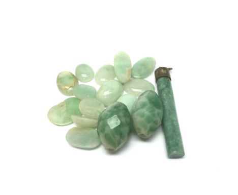 A collection of jade stones and a jade pendant.