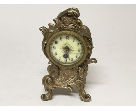 A small French style gilt spelter clock with scroll decoration.