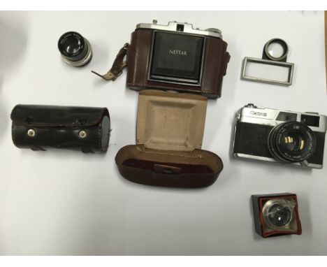 A group of cameras and accessories to include a Wray 4" Super ENL lens, a Canon canonet QL19, Tarim lenses and others.