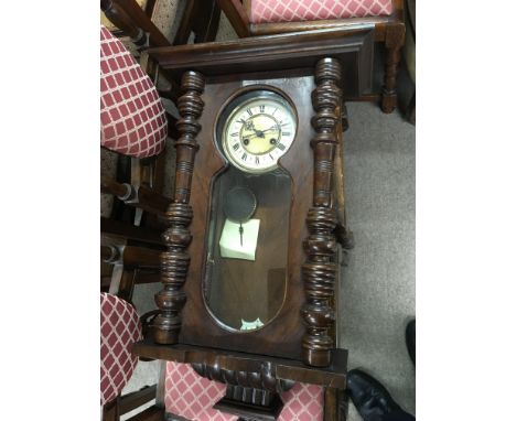 A walnut Vienna wall clock with a visible movement.