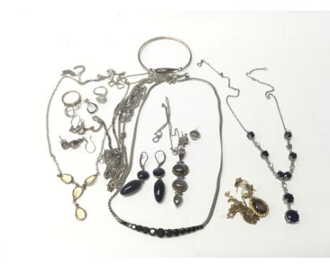 A collection of mostly silver jewellery to include a sapphire set necklace, semi-precious stone set necklaces, earrings and a