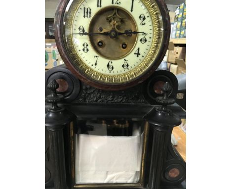 A Victorian marble mantle clock with visible pendulum