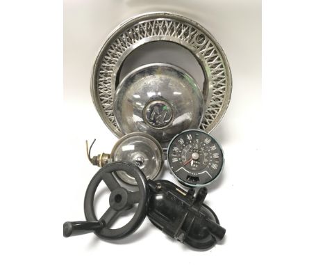 A collection of vintage car parts to include a speedometer, headlights and a Morris Miner hub cap.