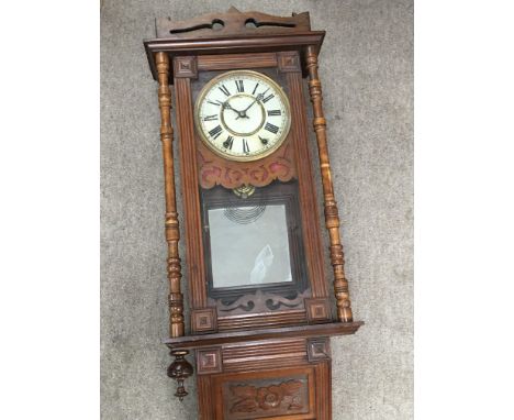 A Walnut wall clock with a mirrored plaque.