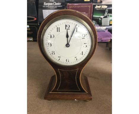A  Edwardian mahogany hour glass shape mantle clock the enamel dial with Arabic numerals on brass feet