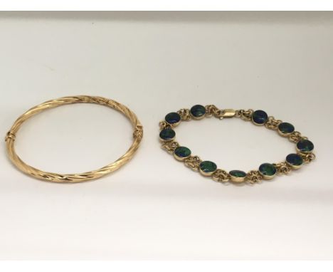 A 14k gold bracelet set with marbled effect stones and an unmarked gold twist bangle