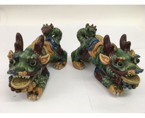 A pair of Chinese pottery Foo dogs.Approx 23cm long
