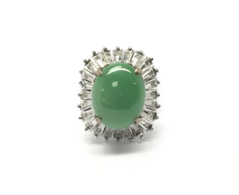 An 18ct white gold ring set with a central oval jade stone, flanked by very small diamonds. Total weight approx 9.8 grams, ri