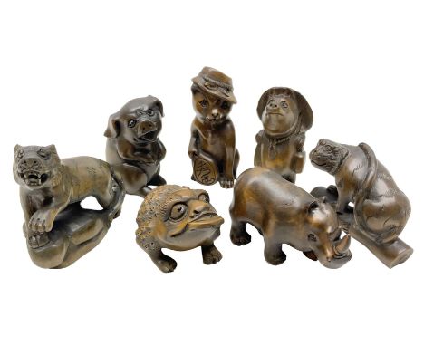 Seven netsuke, modelled as a tiger, pig, cat in a hat, rhino, mythical creature, bear in a hat and a tiger