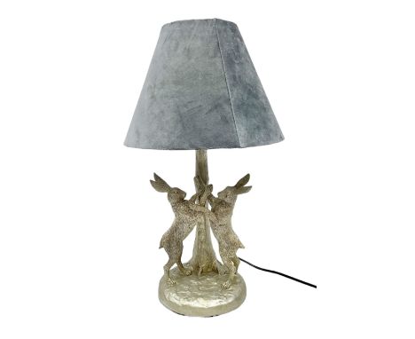 Silver composite table lamp, modelled as a pair of boxing hares, with a grey velvet shade, H45cmDimensions: Height:&nbsp;48cm