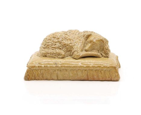 A Brampton pottery figure early 19th century, of a poodle sleeping on a cushion,9cm wideProvenance: The Brampton poodle was a