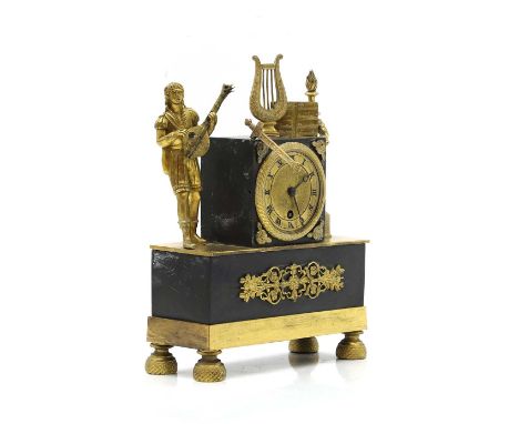 A Regency ormolu cased mantel timepiece 19th century, decorated with a figure of a musician and other ornament, on a plinth b