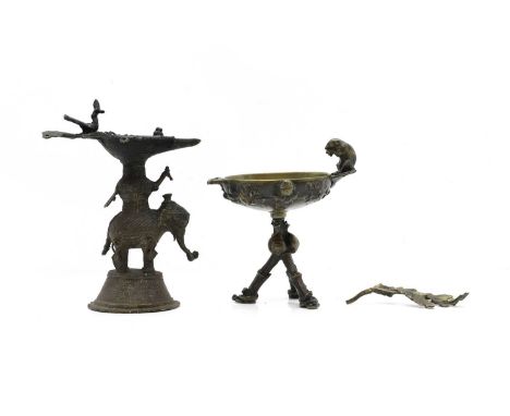 An Indian Dhokra oil lamp  early 20th century, modelled as an elephant,  21cm high together with a bronze bowl on stand, 20th