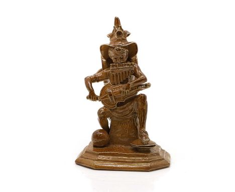 A Doulton stoneware 'Merry Musician' figure  c.1905, by George Tinworth, of a young boy playing the pipes and a guitar, with 