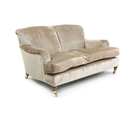 A velvet-upholstered love seat in the Howard-style, of recent manufacture, raised on ring-turned supports terminating in bras