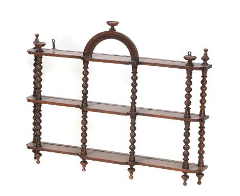 A mahogany wall shelf,  three shelves with bobbin supports, with arched pediment 70cm wide 12cm deep 58cm highProvenance: The