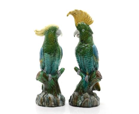 A pair of majolica glazed pottery cockatoos,  19th Century, glazed in blue, brown, green and yellow, moulded mark to the unde