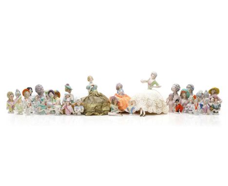 A collection of porcelain half-doll figures, 20th century, various sizes, mostly ladies, four mounted with fabric, with legs,