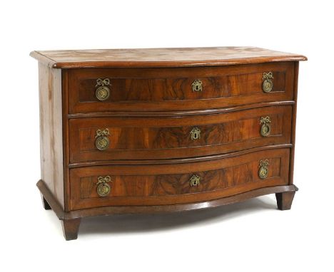 A walnut commode, 18th century and later, Continental, the serpentine top above three drawers each with gilt metal handles, a