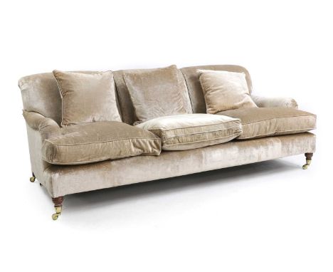 A velvet-upholstered two-seat sofa in the Howard-style, of recent manufacture, raised on ring-turned supports terminating in 