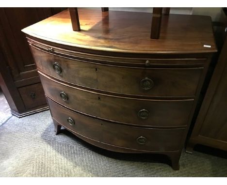 A George III mahogany bowfront chest of drawers, circa 1800, moulded top brushing slide, three long drawers with brass ring h