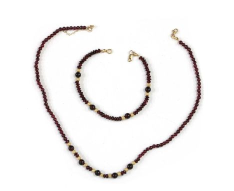 A gold and garnet bead necklace and bracelet suite, with spherical garnet beads, freeform rondelle garnet beads, and gold sph