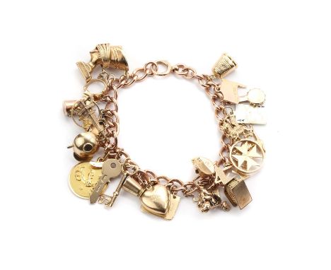 A gold charm bracelet,a 9ct gold curb link bracelet with half solid bolt ring, suspending twenty six charms, to include a gol