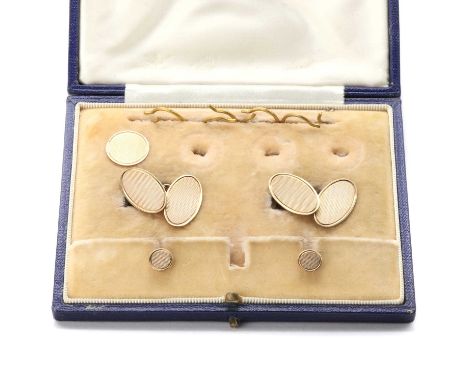A cased dress set, comprising a pair of 9ct gold oval cufflinks with engine turned decoration, two dress studs and one button