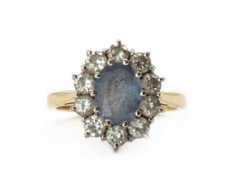 An 18ct gold sapphire and diamond cluster ring, an oval mixed cut sapphire to surround of brilliant cut diamonds, all claw se