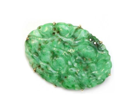 A gold mounted jade plaque brooch, a carved, pierced jadeite jade plaque, claw set to a gold wire frame, with pin and safety 