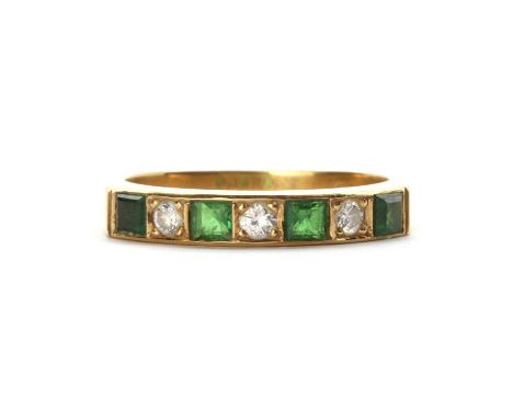 An 18ct gold tsavorite garnet and diamond half eternity ring, a row of alternating square step cut tsavorite garnets and bril