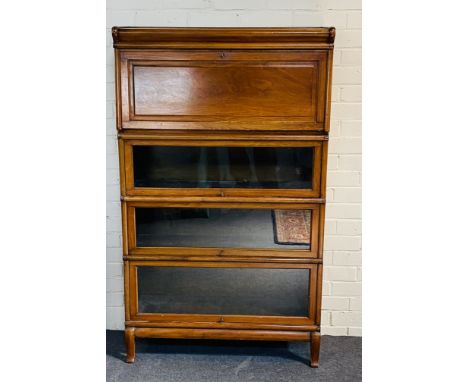 An early 20th century walnut Globe Wernicke four tier bookcase, with three up and over glazed doors and a secretaire panelled
