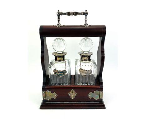 A contemporary tantalus with silver mounts, containing two cut glass decanters with silver collars and labels, complete with 