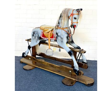 A painted dapple grey rocking horse on a pine swing rocker frame, complete with leather stirrups and saddle. 138cms wide x 46