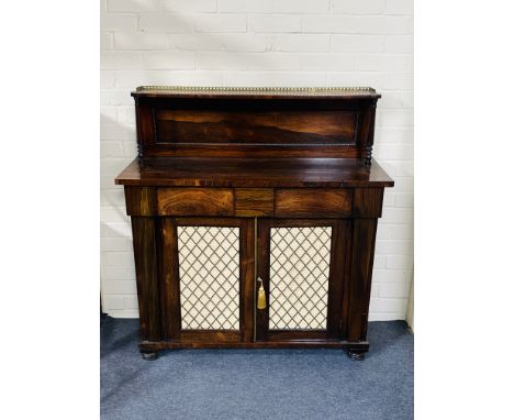 A narrow mid 19th century rosewood chiffonier with a panel backed upstand with a brass gallery above, over two frieze drawers