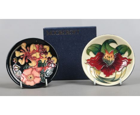 Two Moorcroft pin dishes one in the Anna Lily pattern by Nicola Slaney the other in the Oberon pattern by Rachel Bishop in bo