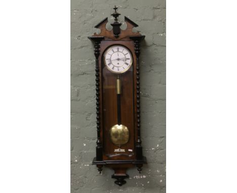 A C19th walnut cased single train Vienna wall clock. With enamel dial incorporating subsidiary seconds with ebonized moulding