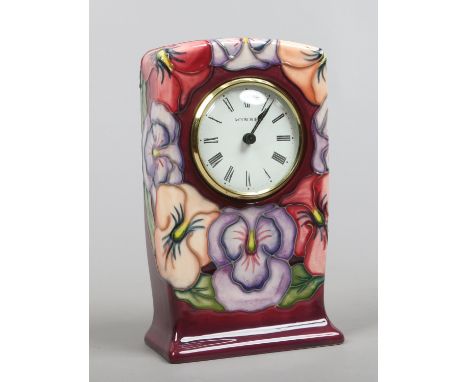 A Moorcroft mantel clock decorated in the pansy pattern by Rachel Bishop first quality.