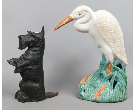 A painted cast iron door stop along with a large ceramic model of a heron.