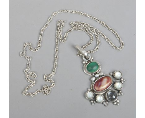 A silver pendant on chain set with malachite and moonstone.