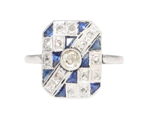 AN ART DECO SAPPHIRE AND DIAMOND RING. the rectangular head set with a central round cut diamond flanked by a pattern of zig-