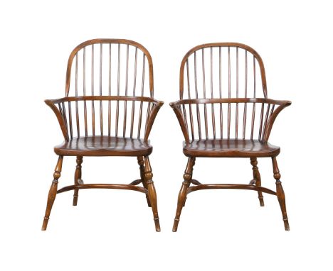 A PAIR OF WINDSOR ARMCHAIRS. The arched comb backs above a shaped solid seat and turned legs with arched stretchers, 65cm wid
