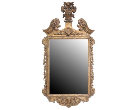 AN 18TH CENTURY ROCOCO GILTWOOD MIRROR. Having a leafy scroll pediment above leafy scroll terminating swan necks, above a car