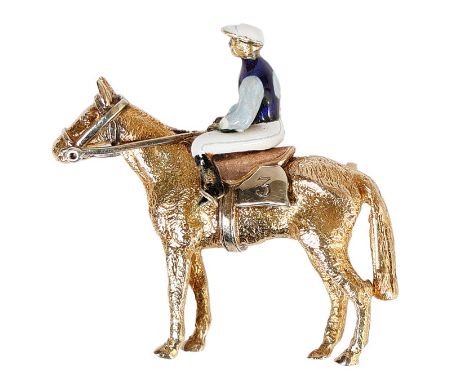 A 9 CARAT GOLD AND ENAMEL BROOCH MODELLED AS A HORSE AND JOCKEY. The jockey with white cap, navy and turquoise silks, white j