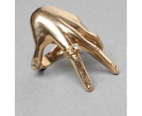 A 9CT GOLD COCKTAIL RING shaped as a lady's left hand wearing a diamond solitaire "ring", stamped 9k and hallmarked, size M (