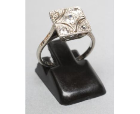 AN ART DECO DIAMOND PLAQUE RING, the square panel centred by a brilliant cut stone of approximately 0.25cts with four similar