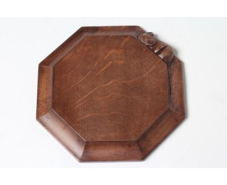 A ROBERT THOMPSON ADZED OAK TEAPOT STAND/CHOPPING BOARD of octagonal form, the dished sides with carved mouse trademark in re