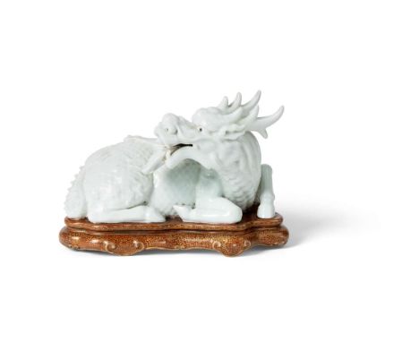  CHINESE WHITE-GLAZED MODEL OF A QILIN QING DYNASTY, 19TH CENTURY 清 乾隆款 白釉麒麟連座擺件moulded as a mythical beast seated with its f