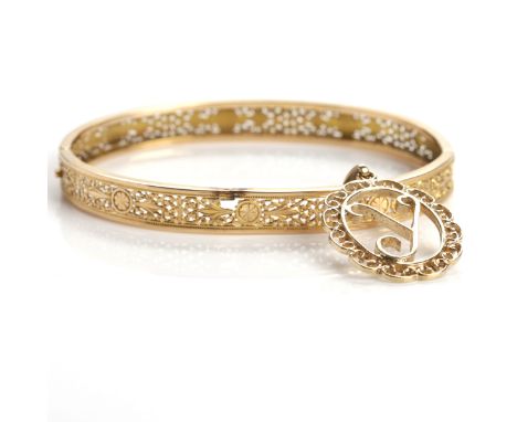 VICTORIAN STYLE GOLD BANGLE 
with pierced scrolling decoration, marks worn; together with a nine carat gold pendant, 12.2gms 