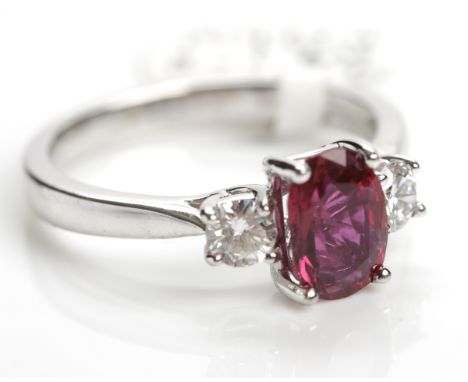 RUBY AND THREE STONE RING
the central oval ruby of approximately 1.24 carats flanked by two diamonds totalling approximately 